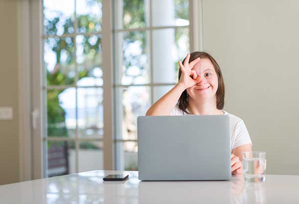 Foto von Mädchen mit Downsyndrom am Laptop